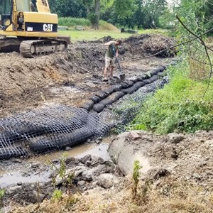 Filtrexx Greenloxx vegetative logs being installed to stabilize the streambank through natural/green techniques where the roots of the vegetation will grow into and "lock" the streambank in place.