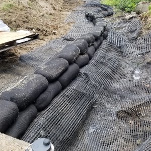 Filtrexx Greenloxx vegetative logs being installed to stabilize the streambank through natural/green techniques where the roots of the vegetation will grow into and "lock" the streambank in place.